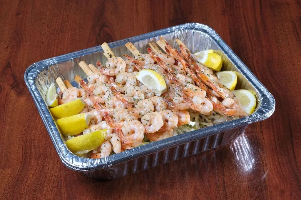 Garlic shrimp skewer platter with lemon wedges